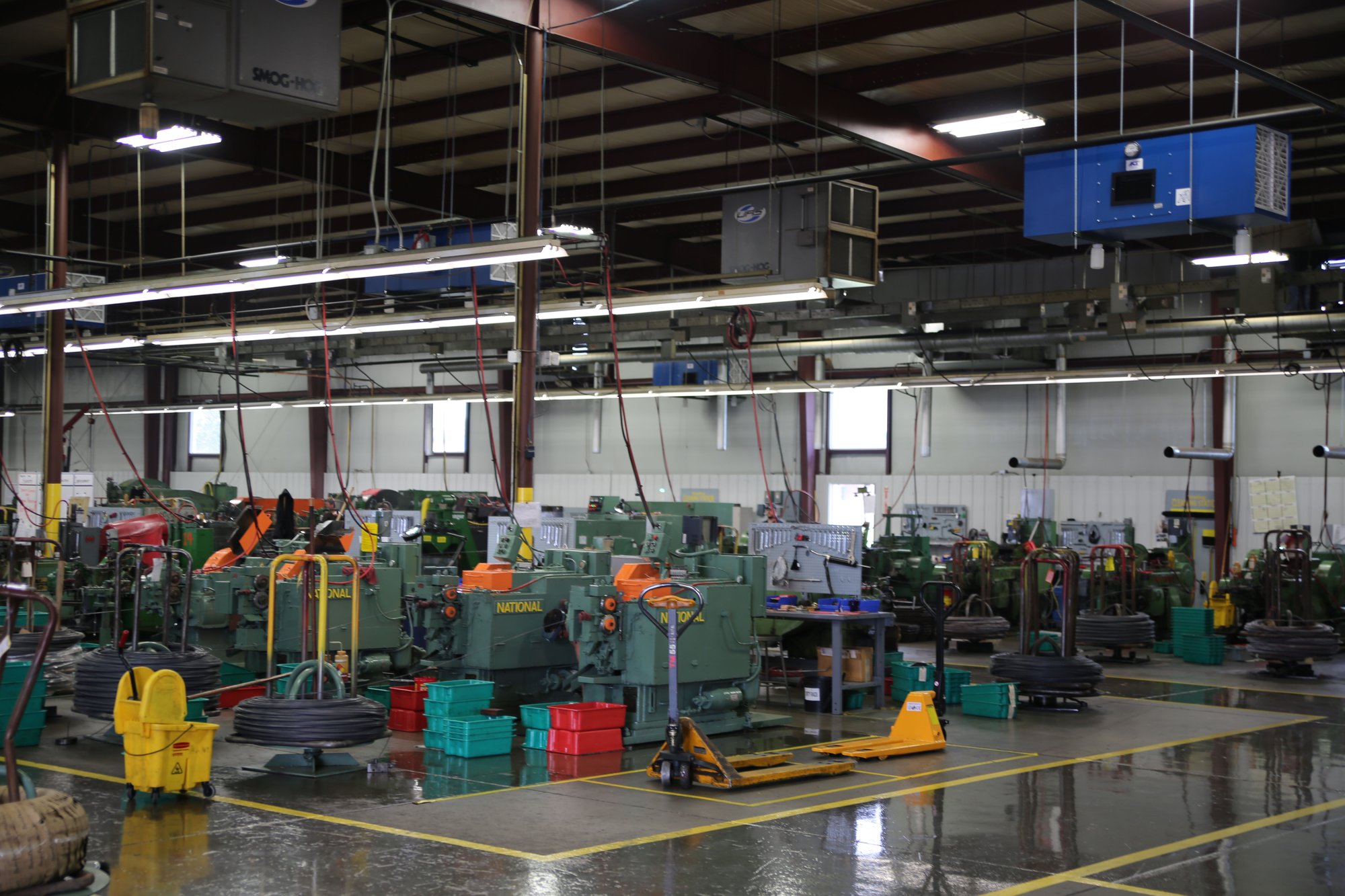 Blue Ox industrial air filtration system positioned directly over manufacturing equipment to capture oil mist at the source.